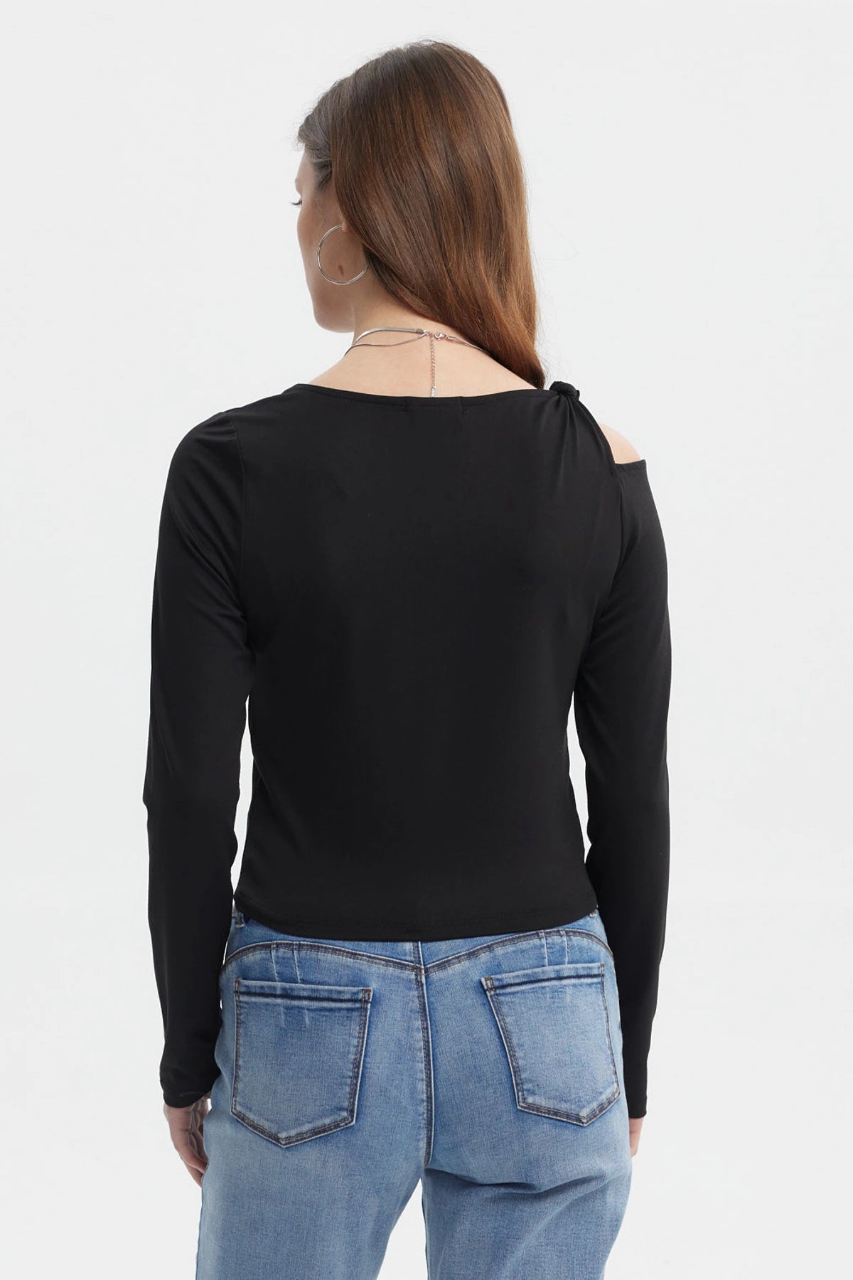 Polera negra de mujer con nudo en el hombro estilo minimalista manga larga sin estampa