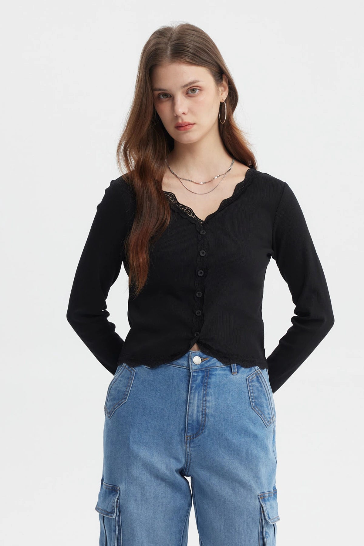Polera negra de mujer con cuello en V y encaje en puños prenda lisa con botones en el frente