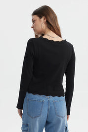 Polera negra de mujer con cuello en V y encaje en puños prenda lisa con botones en el frente