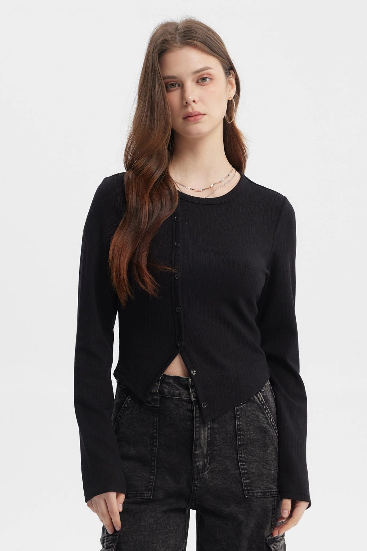 Polera negra de mujer con corte diagonal y botones al frente diseño liso estilo casual urbana