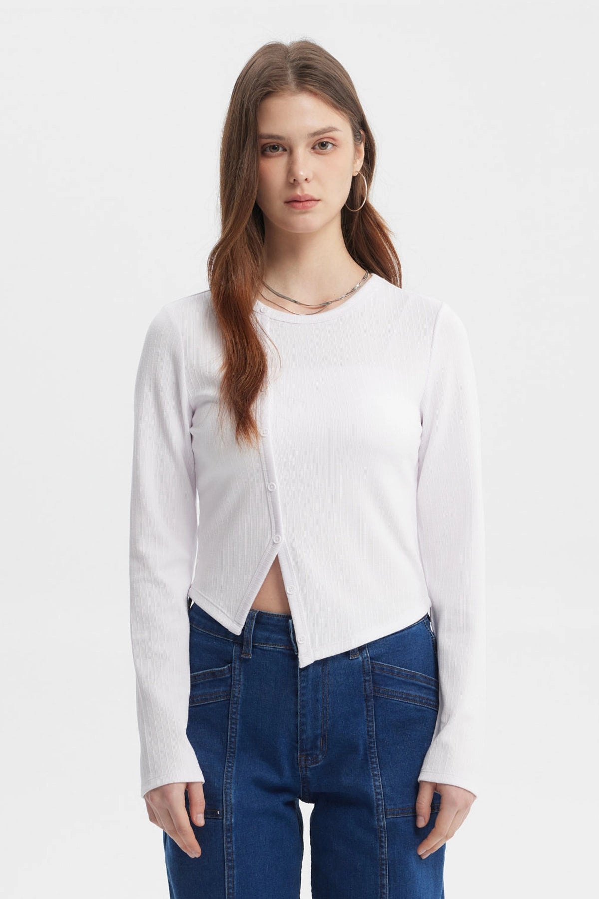 Polera mujer blanca de manga larga con corte diagonal y botones al frente sin estampa visible