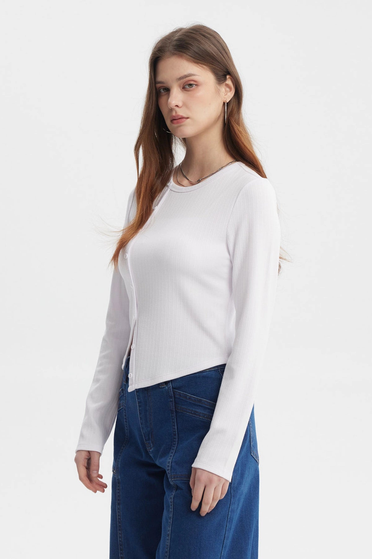 Polera mujer blanca de manga larga con corte diagonal y botones al frente sin estampa visible