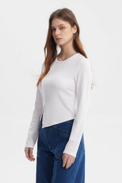 Polera mujer blanca de manga larga con corte diagonal y botones al frente sin estampa visible