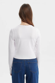 Polera mujer blanca de manga larga con corte diagonal y botones al frente sin estampa visible