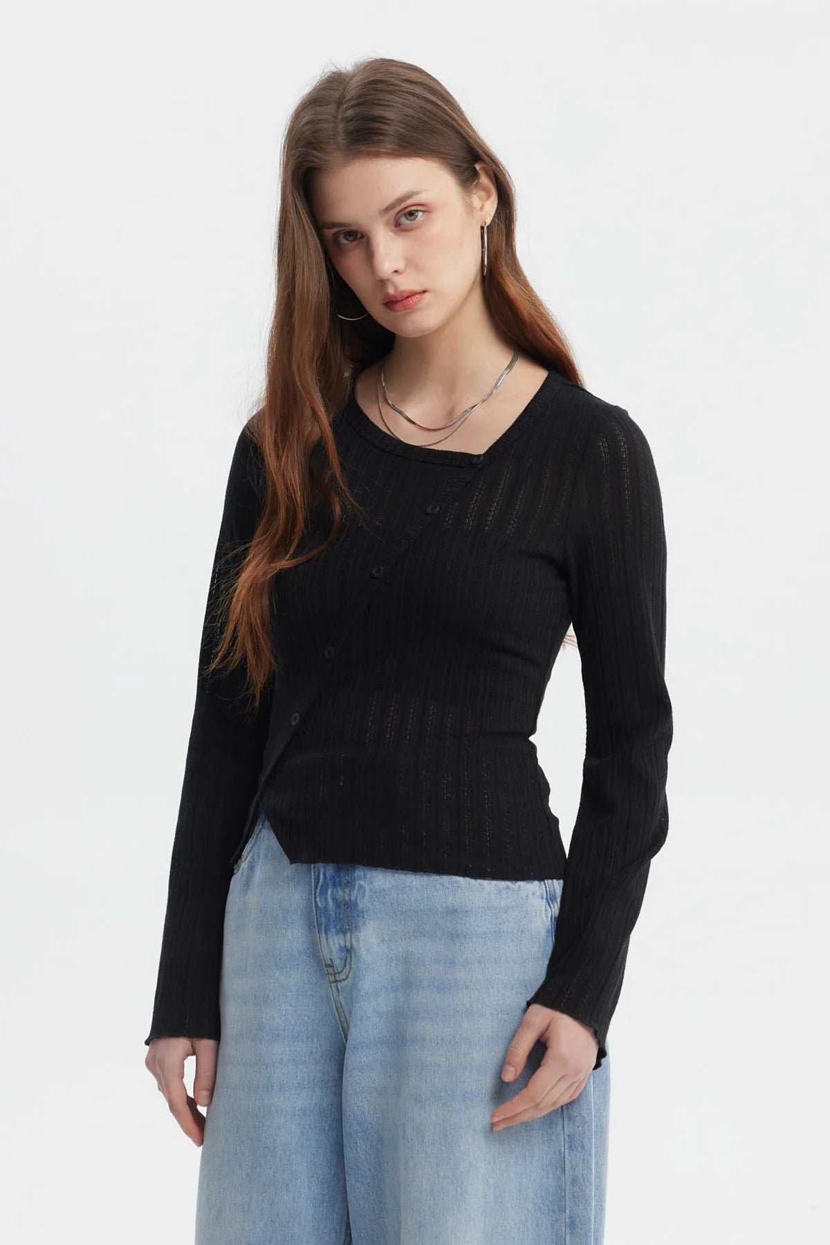 Polera negra asimétrica para mujer con botones en el frente y mangas largas estilo acampanado sin estampa visible