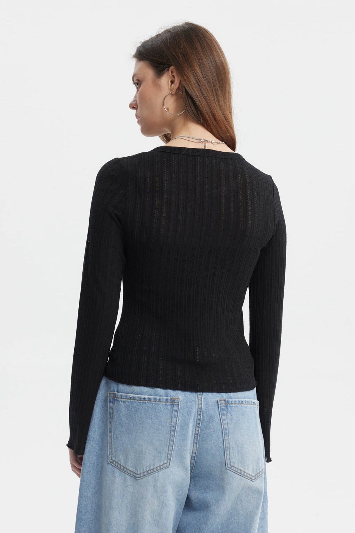 Polera negra asimétrica para mujer con botones en el frente y mangas largas estilo acampanado sin estampa visible