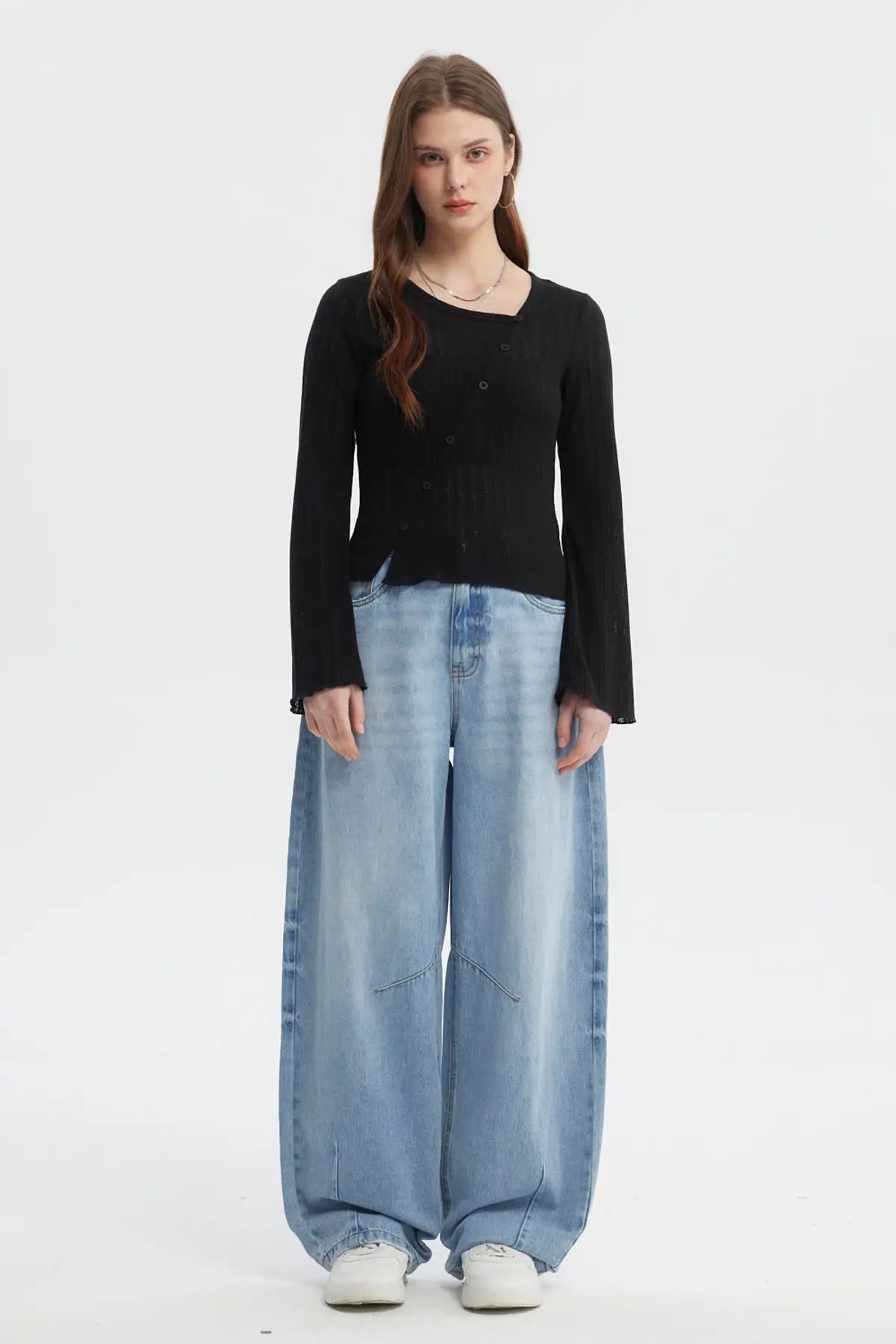 Polera negra asimétrica para mujer con botones en el frente y mangas largas estilo acampanado sin estampa visible