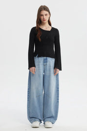 Polera negra asimétrica para mujer con botones en el frente y mangas largas estilo acampanado sin estampa visible