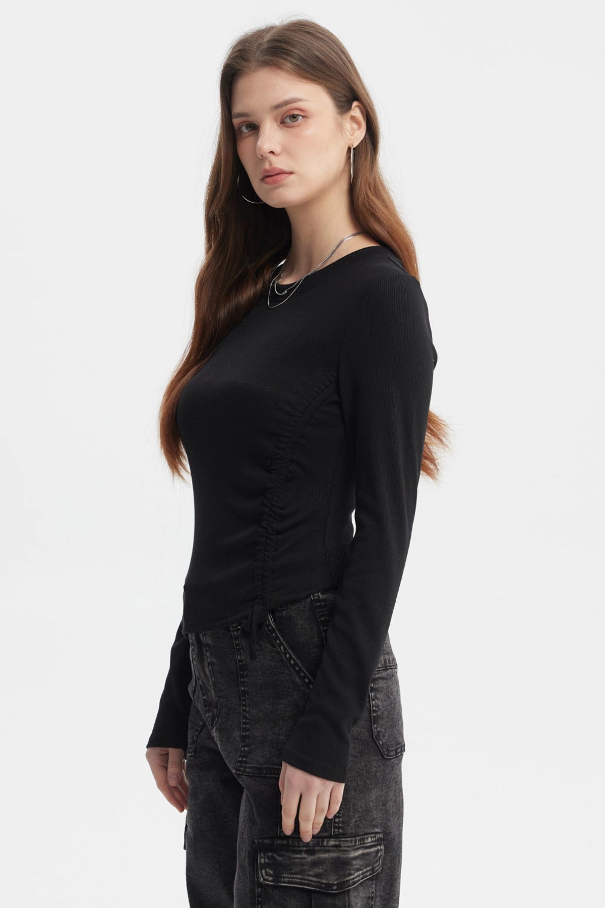 Polera negra de mujer con recogido lateral sin estampa lisa y manga larga ajuste moderno y casual