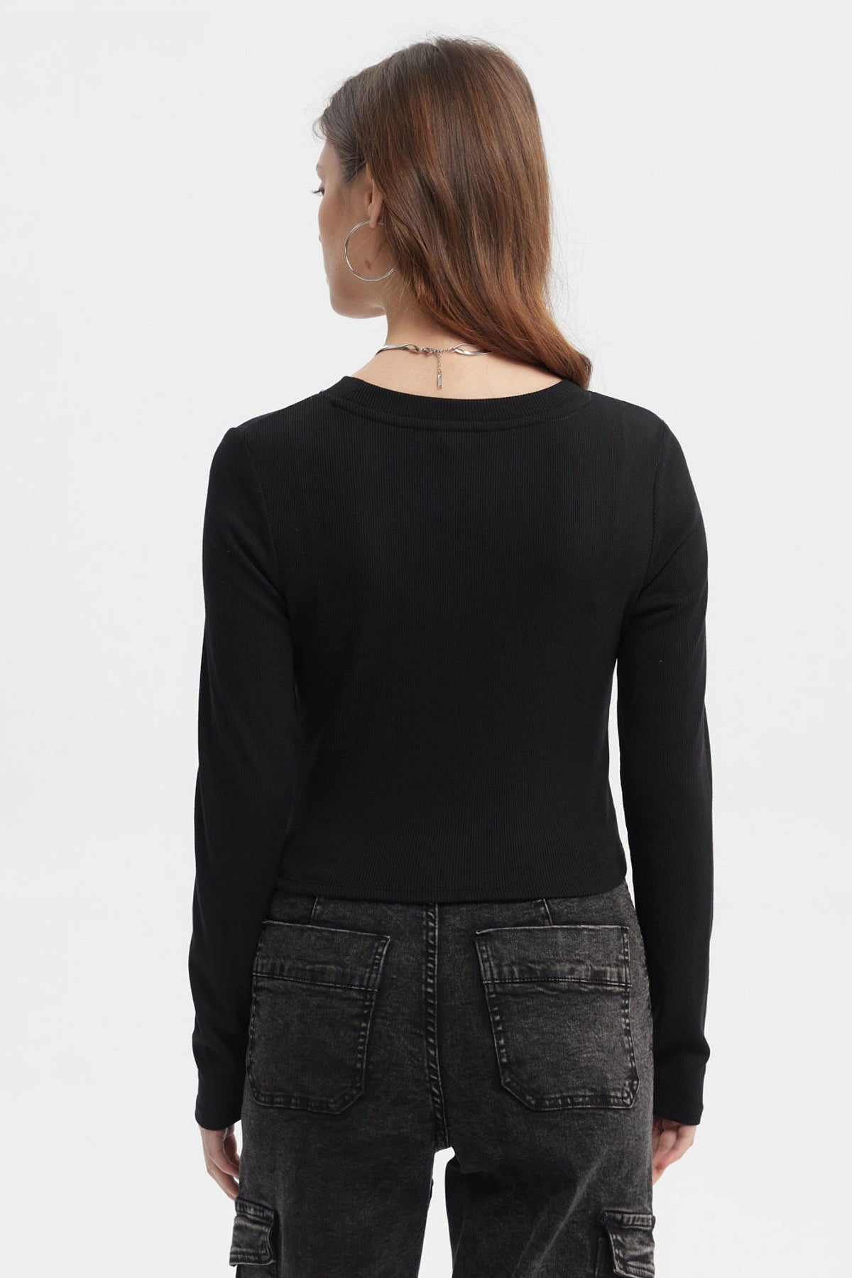 Polera negra de mujer con recogido lateral sin estampa lisa y manga larga ajuste moderno y casual
