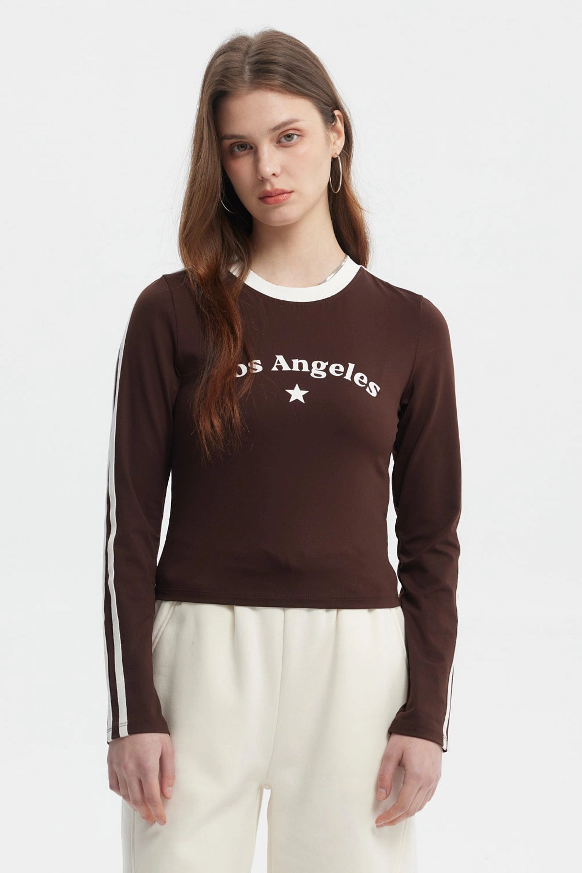 Polera de mujer café oscuro con texto Los Angeles y estrella blanca en el pecho manga larga y franjas blancas en las mangas