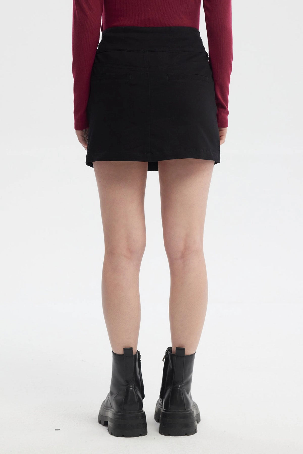 Falda negra de mujer con botones laterales y diseño liso ideal para un look casual con botas robustas