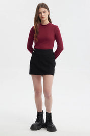 Falda negra de mujer con botones laterales y diseño liso ideal para un look casual con botas robustas