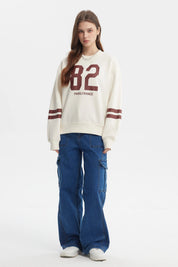 Polerón crema para mujer con número 82 y texto Paris France en el frente estilo casual con rayas en las mangas