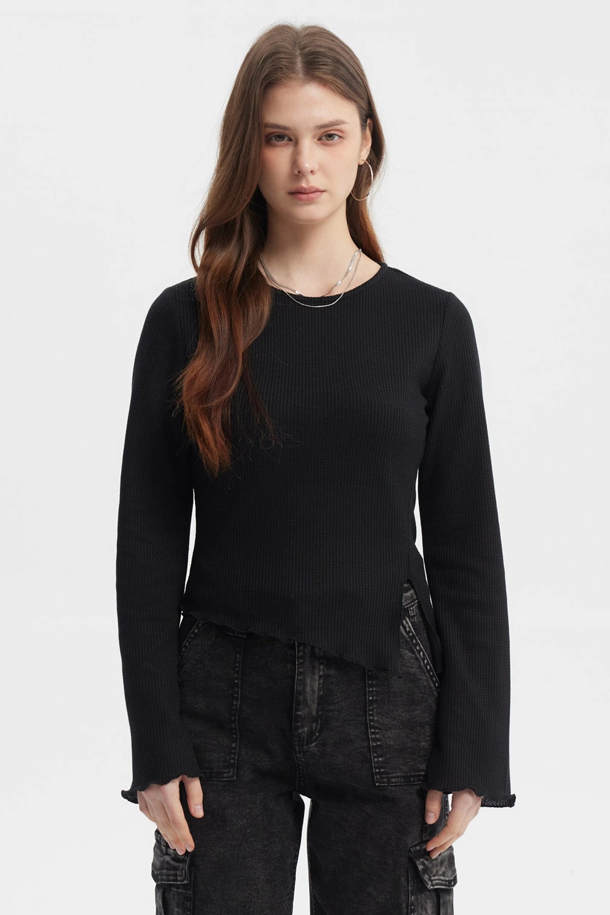 Polera negra para mujer con abertura lateral y mangas largas acampanadas diseño liso ideal para estilo casual moderno