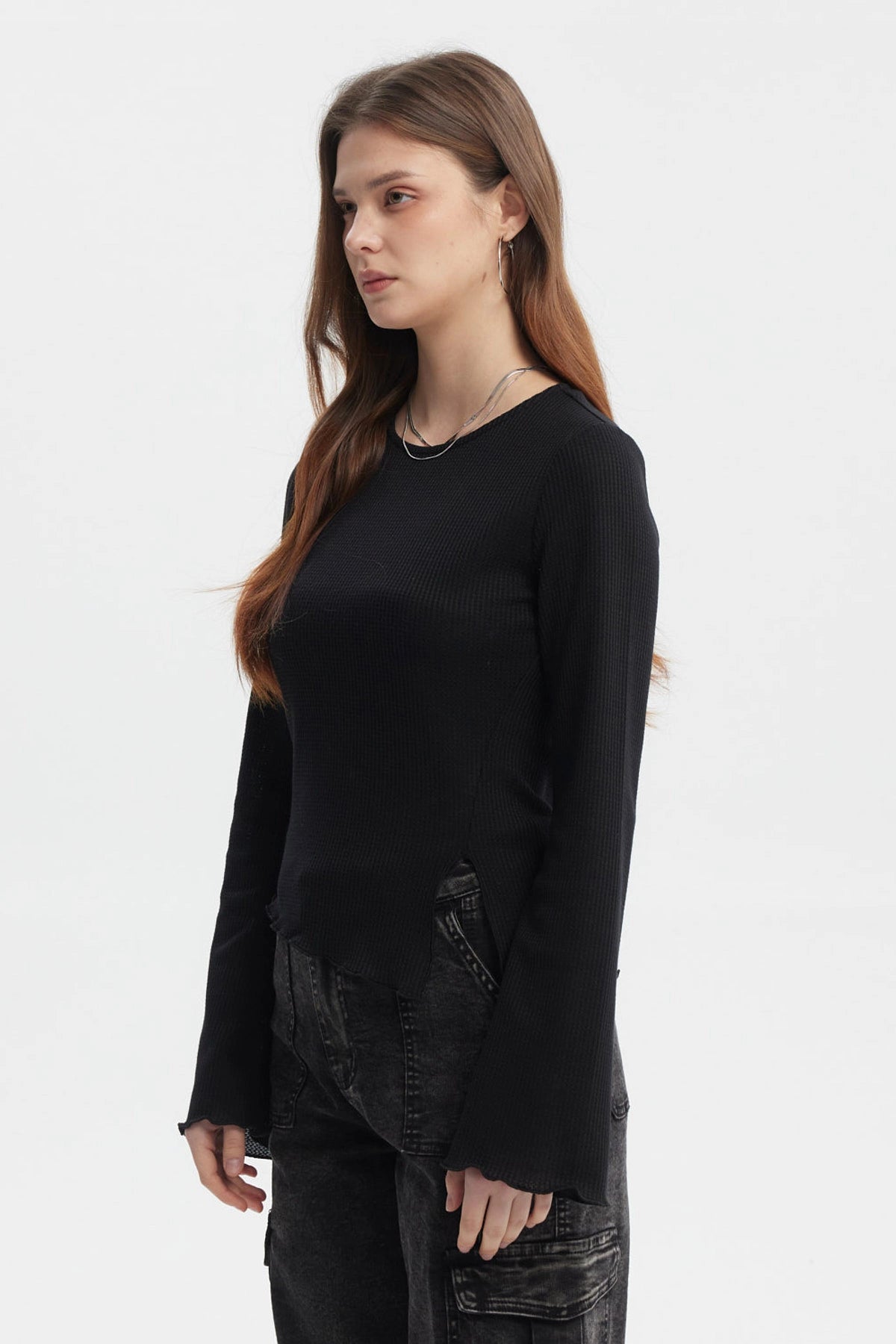 Polera negra para mujer con abertura lateral y mangas largas acampanadas diseño liso ideal para estilo casual moderno