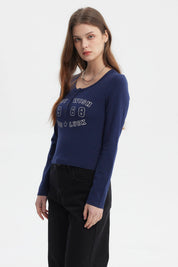 Polera azul de mujer con cuello redondo y botones texto BEST WISH 1968 GOOD LUCK en el pecho estilo casual moderno