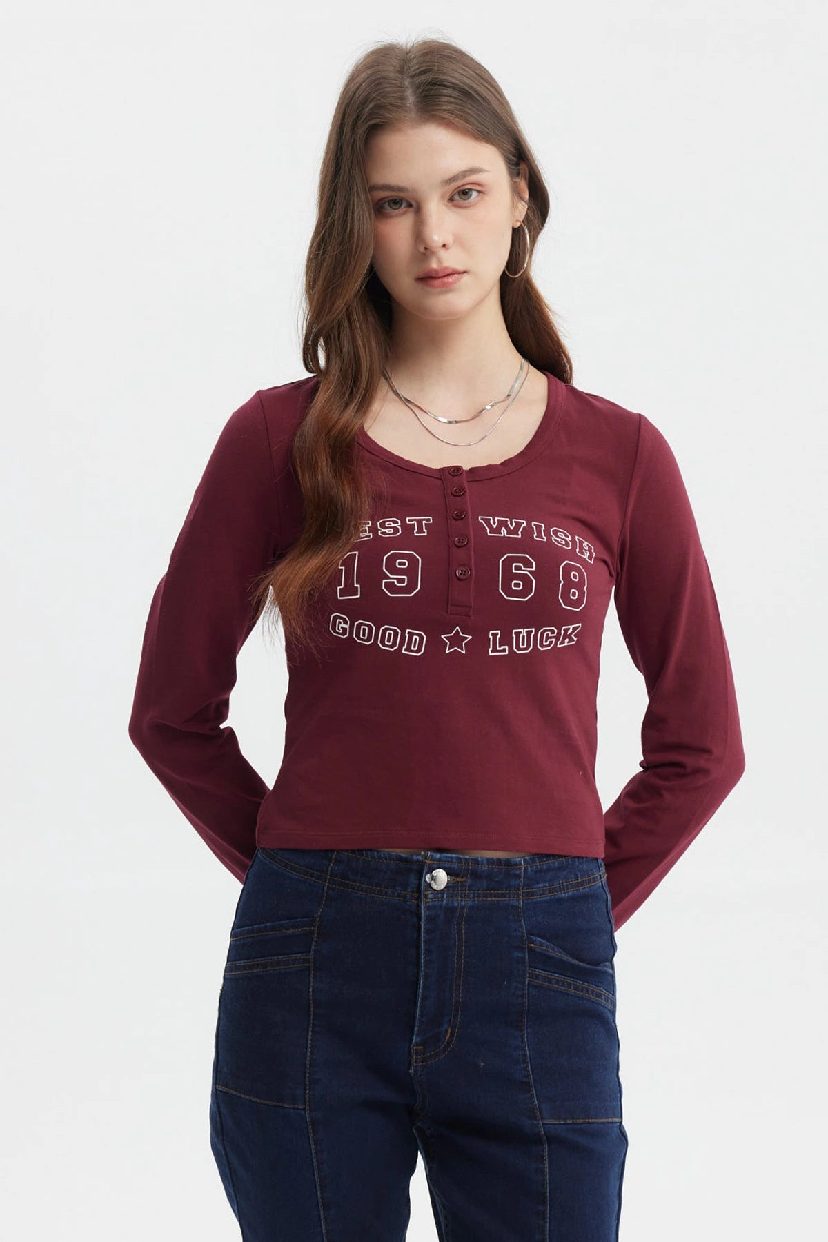 Polera roja de mujer con cuello redondo y botones decorativos frontal texto West Wish 1968 Good Luck estilo casual