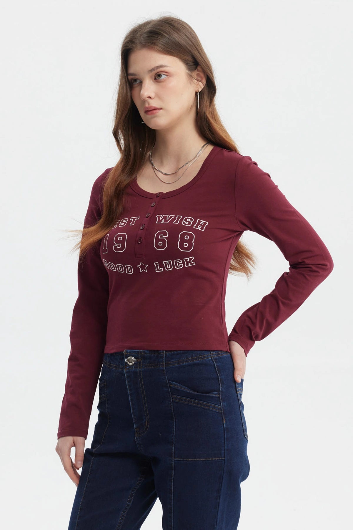 Polera roja de mujer con cuello redondo y botones decorativos frontal texto West Wish 1968 Good Luck estilo casual