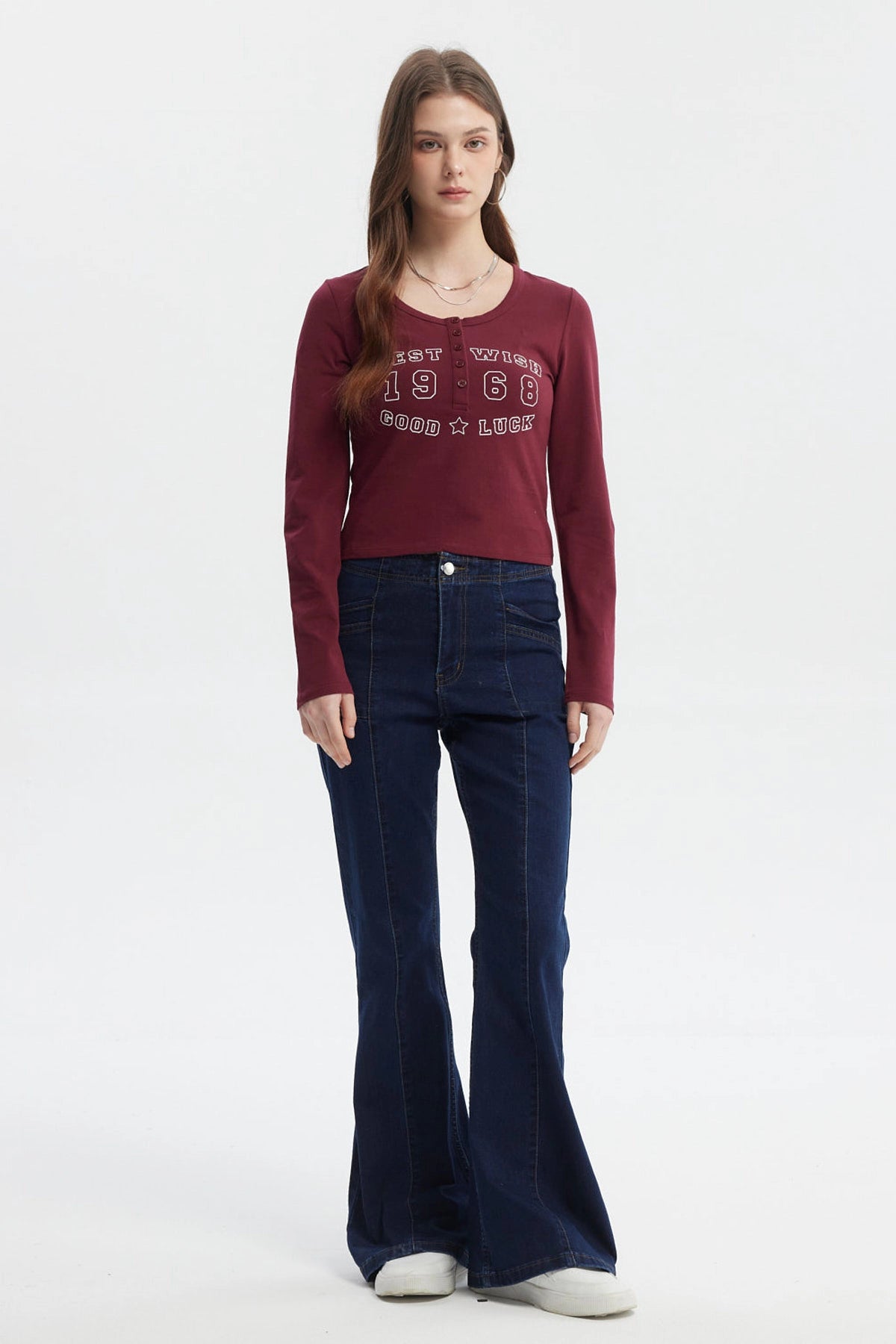 Polera roja de mujer con cuello redondo y botones decorativos frontal texto West Wish 1968 Good Luck estilo casual