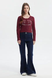 Polera roja de mujer con cuello redondo y botones decorativos frontal texto West Wish 1968 Good Luck estilo casual