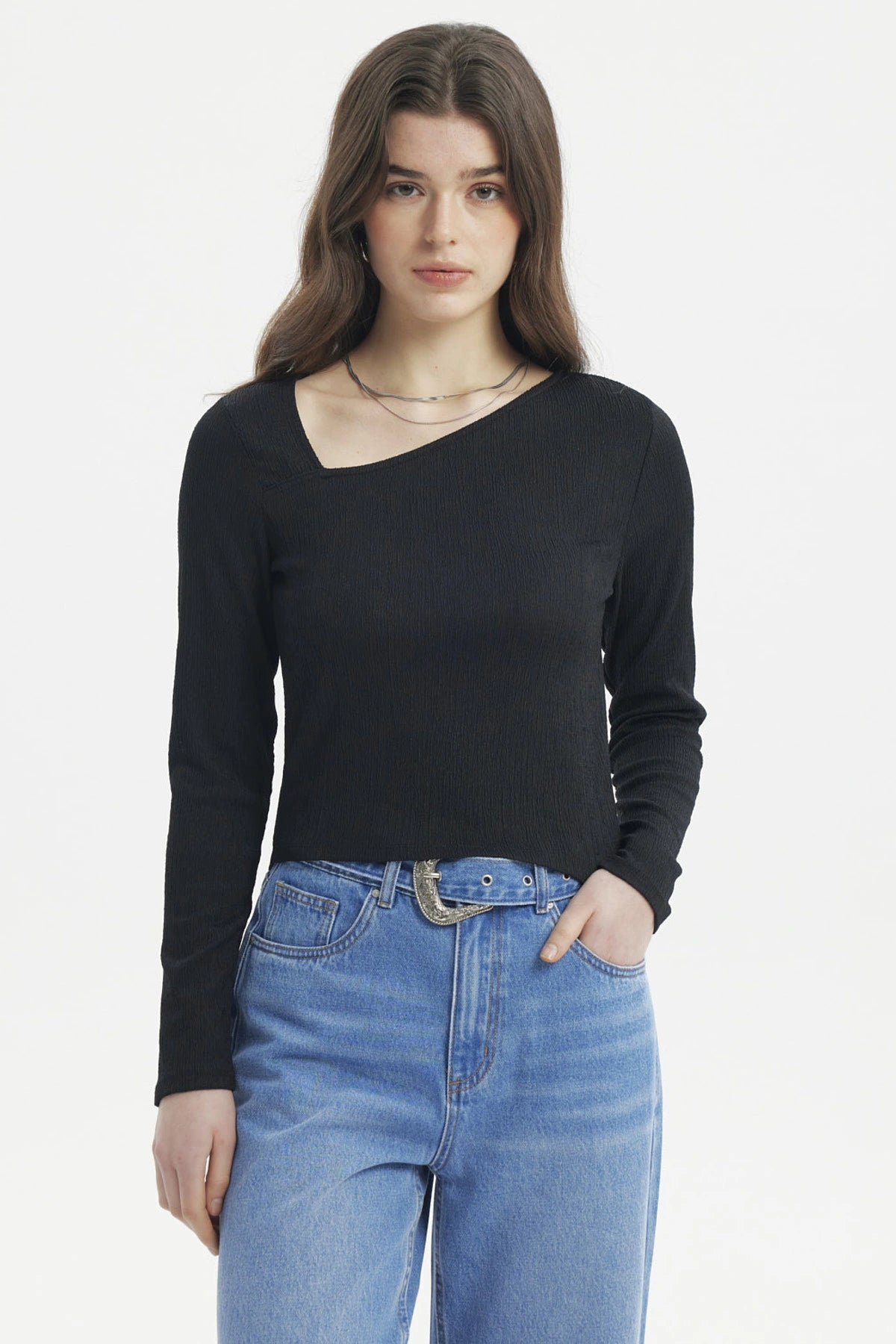 Polera negra de mujer con cuello asimétrico y manga larga lisa