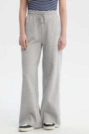 Pantalón buzo gris melange para mujer con cintas blancas a los costados diseño número 89 pequeño en el muslo izquierdo