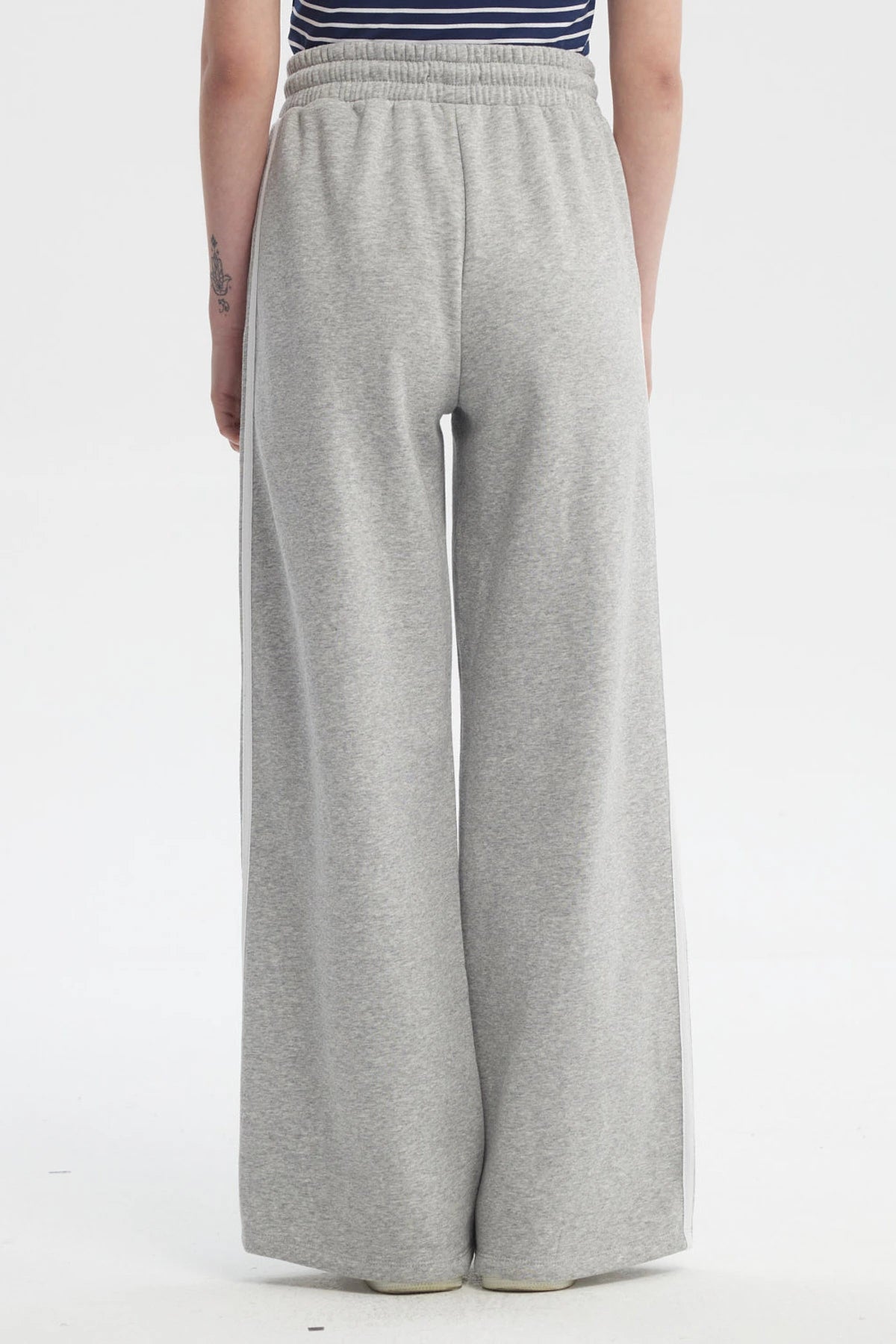 Pantalón buzo gris melange para mujer con cintas blancas a los costados diseño número 89 pequeño en el muslo izquierdo