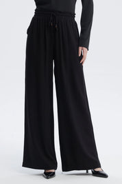 Pantalón negro de mujer con lazo en la cintura de estilo fluido sin estampa visible