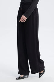 Pantalón negro de mujer con lazo en la cintura de estilo fluido sin estampa visible