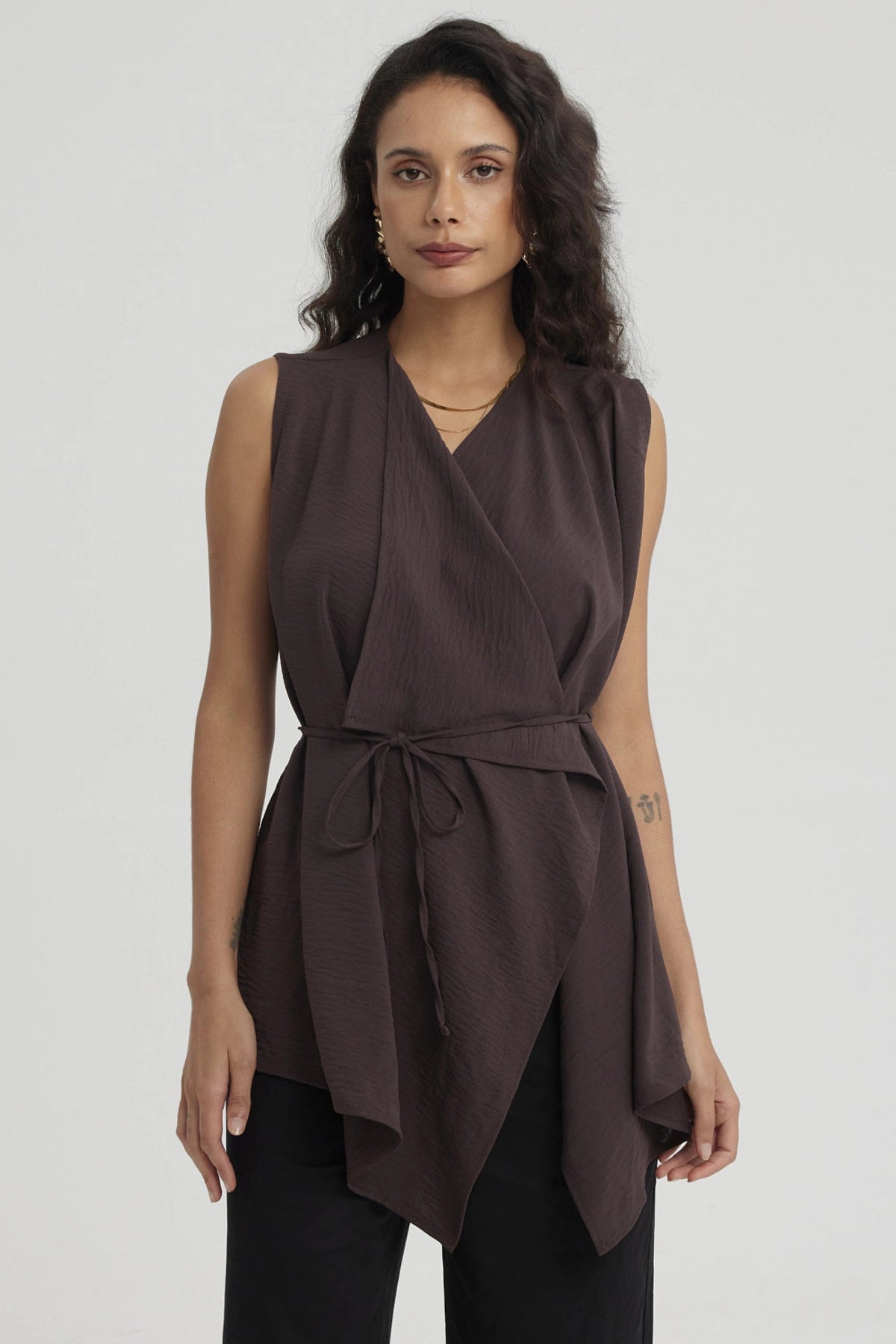 Blusa sin mangas café oscuro con cuello camisero y cinturón en la cintura diseño envolvente y textura ligera lisa