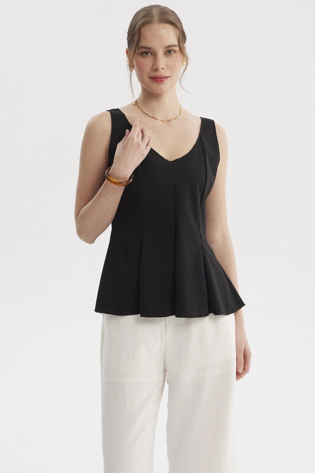 Polera de mujer negra lisa sin mangas con escote en V y diseño peplum
