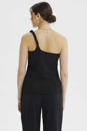 Polera negra asimétrica para mujer con pabilo trenzado y detalle dorado sin estampa visible