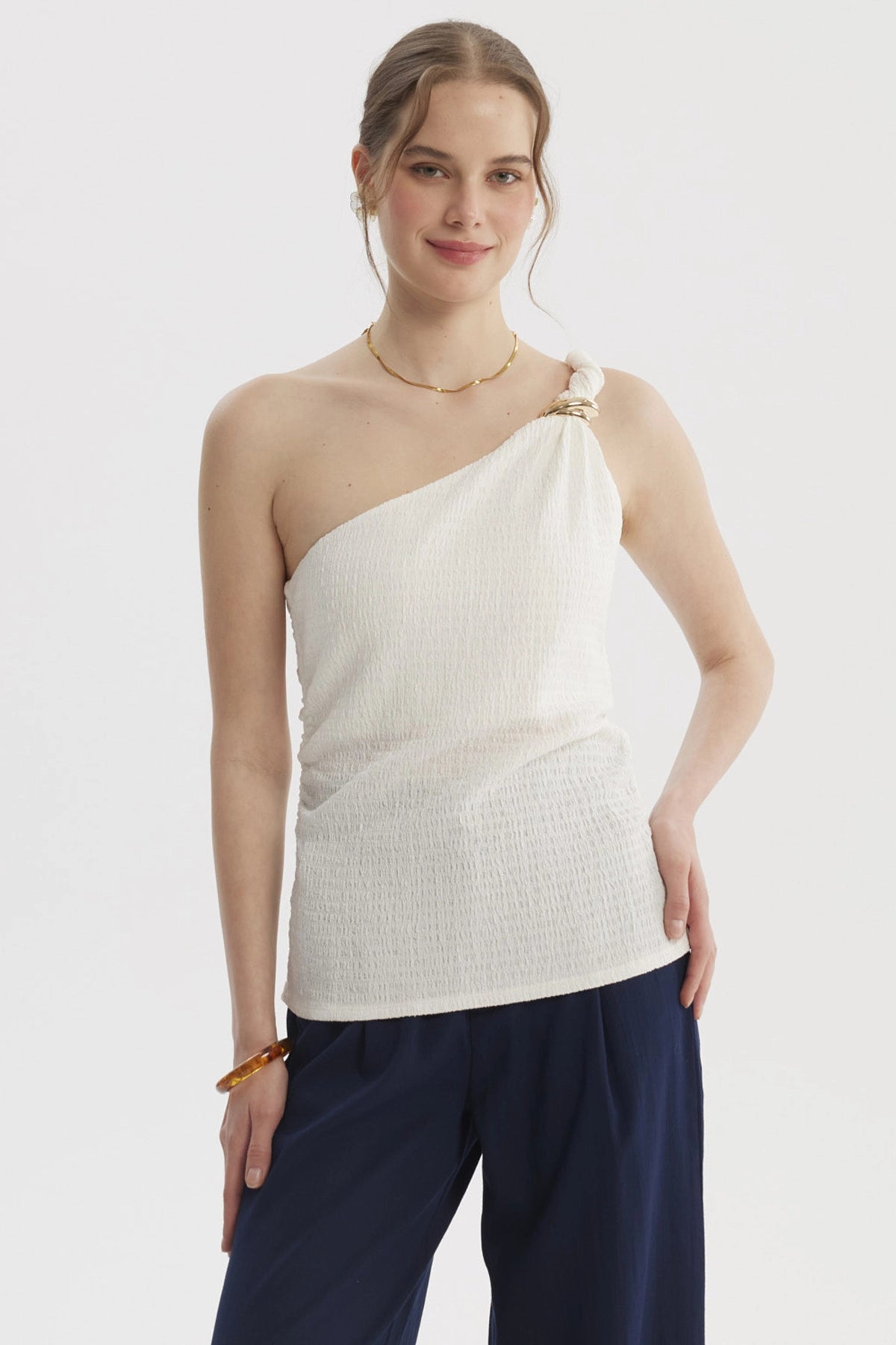 Polera asimétrica crudo con pabilo trenzado en el hombro diseño liso ideal para días de verano relajados