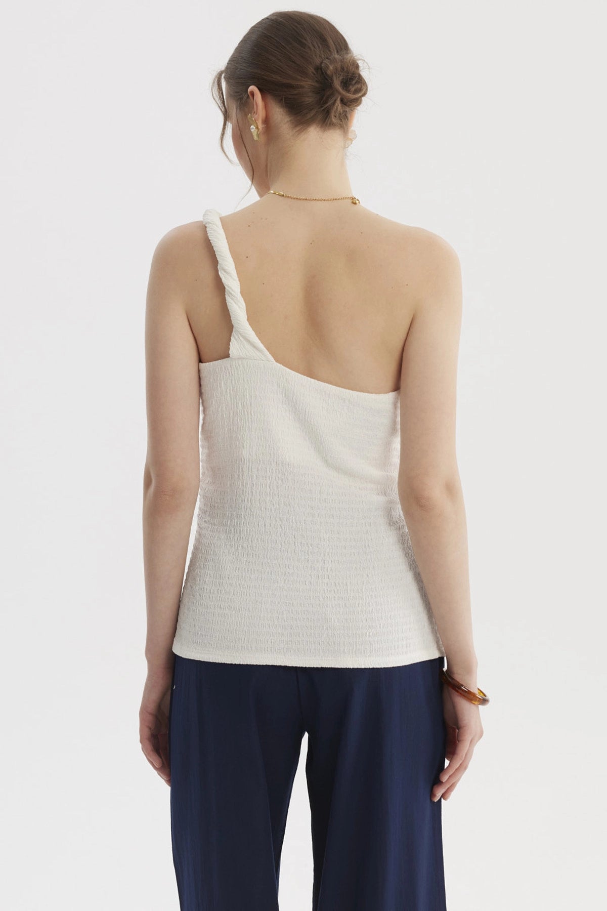 Polera asimétrica crudo con pabilo trenzado en el hombro diseño liso ideal para días de verano relajados
