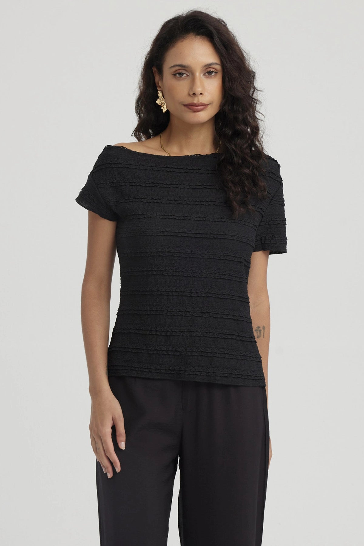 Polera negra para mujer con cuello asimétrico textura de líneas horizontales diseño liso y elegante