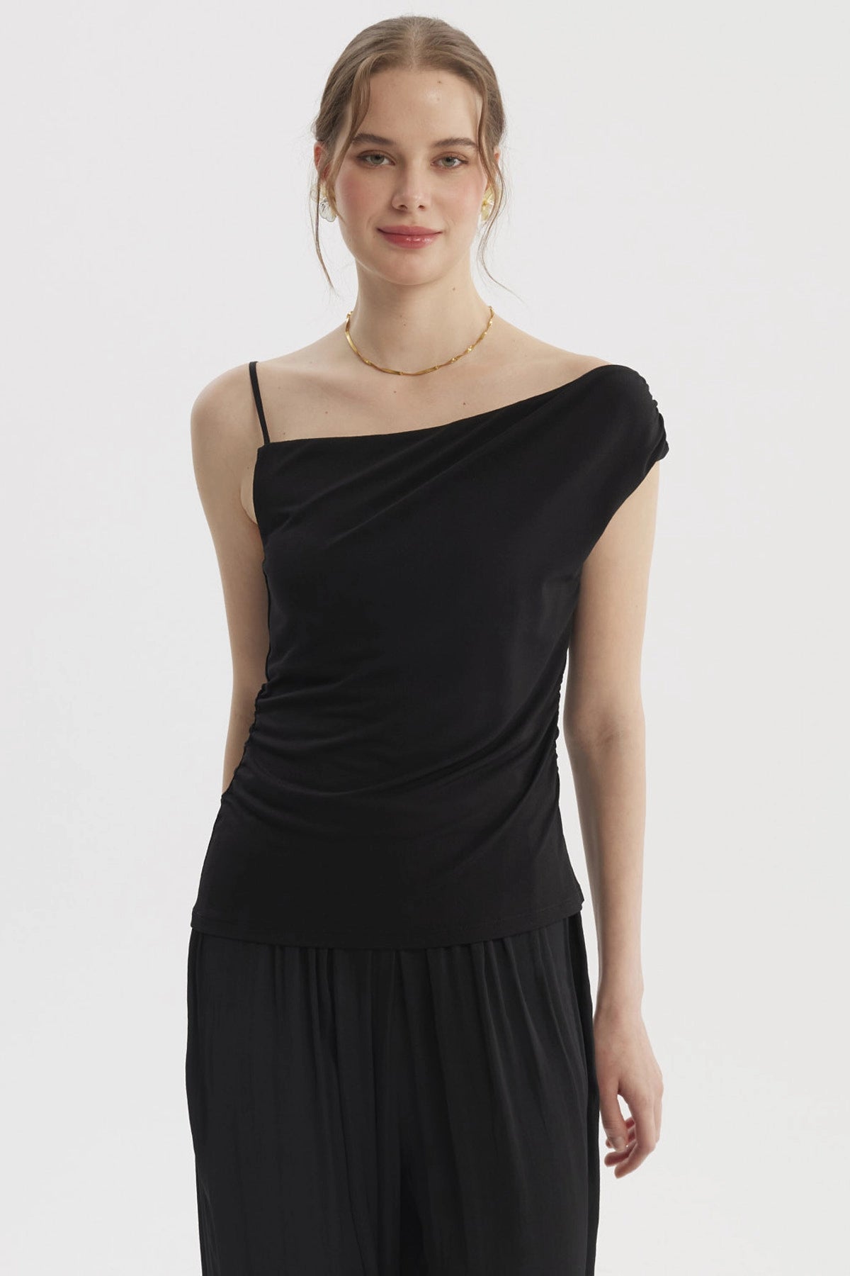 Polera de mujer negra con escote asimétrico y pabilo ajustado diseño liso ideal para un look elegante y moderno
