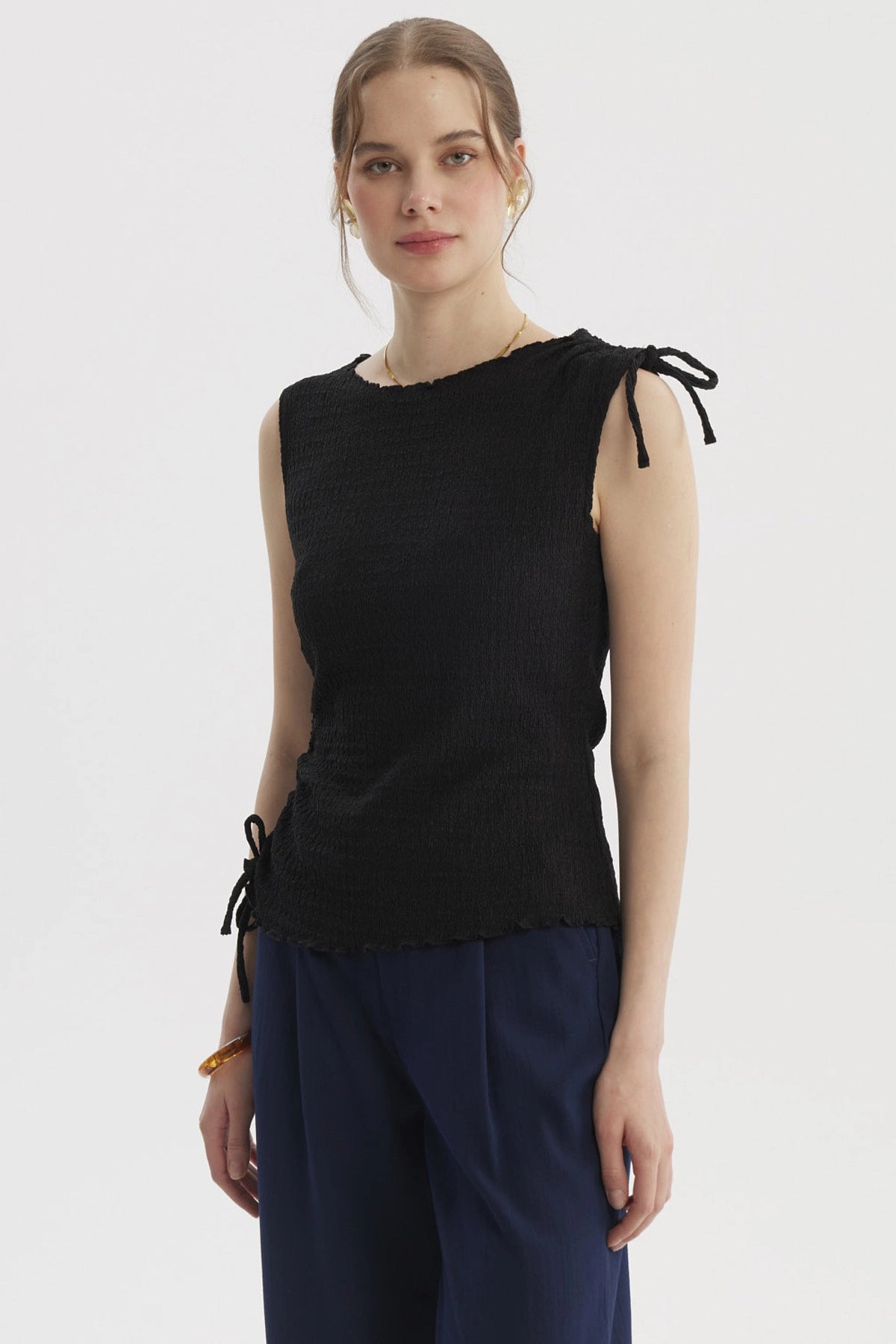 Polera negra sin mangas con detalle de amarre en el costado diseño liso ideal para un look elegante y casual