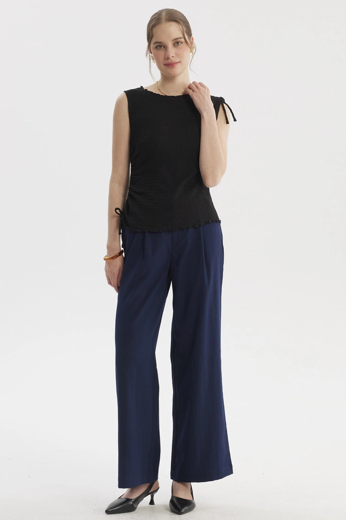 Polera negra sin mangas con detalle de amarre en el costado diseño liso ideal para un look elegante y casual