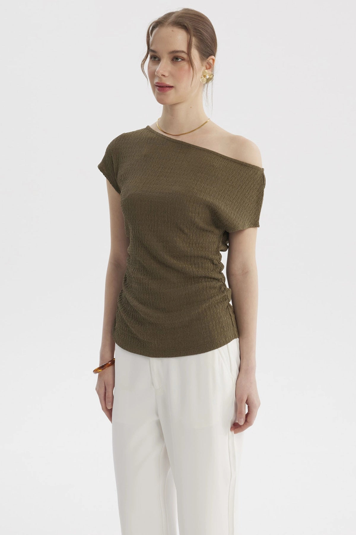 Polera verde olivo de mujer con escote asimétrico y textura lisa ideal para un look casual elegante