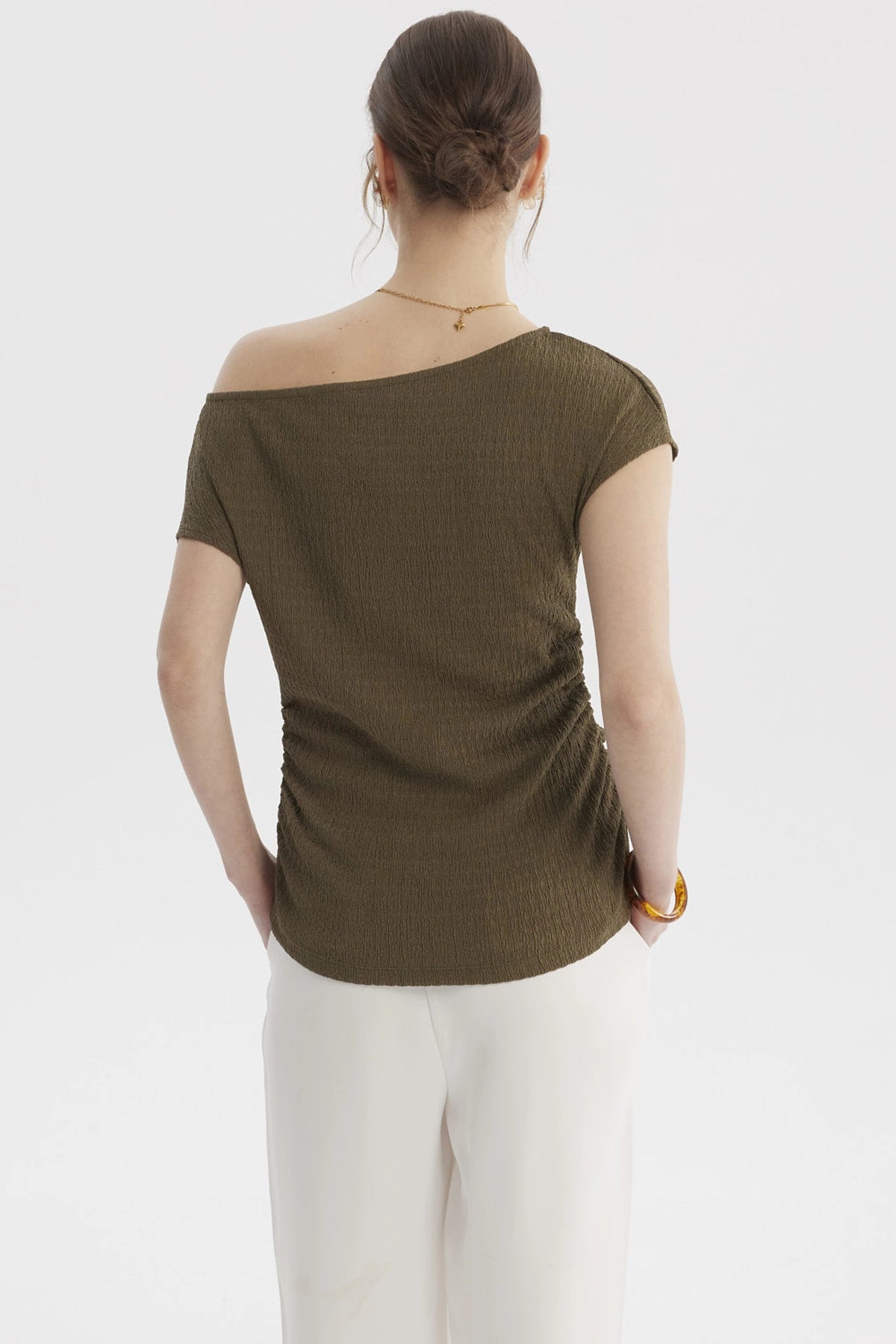 Polera verde olivo de mujer con escote asimétrico y textura lisa ideal para un look casual elegante