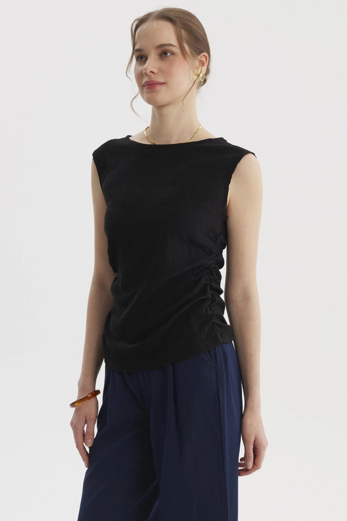 Polera negra para mujer con cuello bote y drapeado lateral sin estampa visible