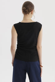 Polera negra para mujer con cuello bote y drapeado lateral sin estampa visible