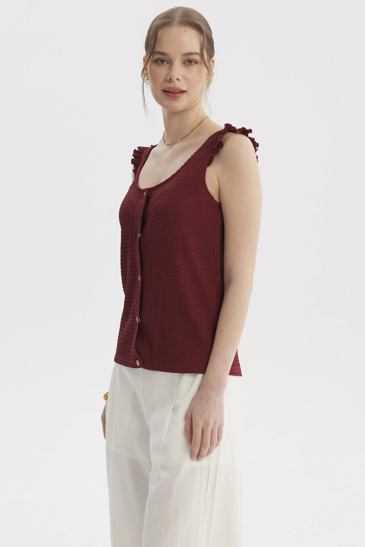 Polera sin mangas color vino con botones dorados y detalles de vuelo en los hombros lisa elegante y moderna