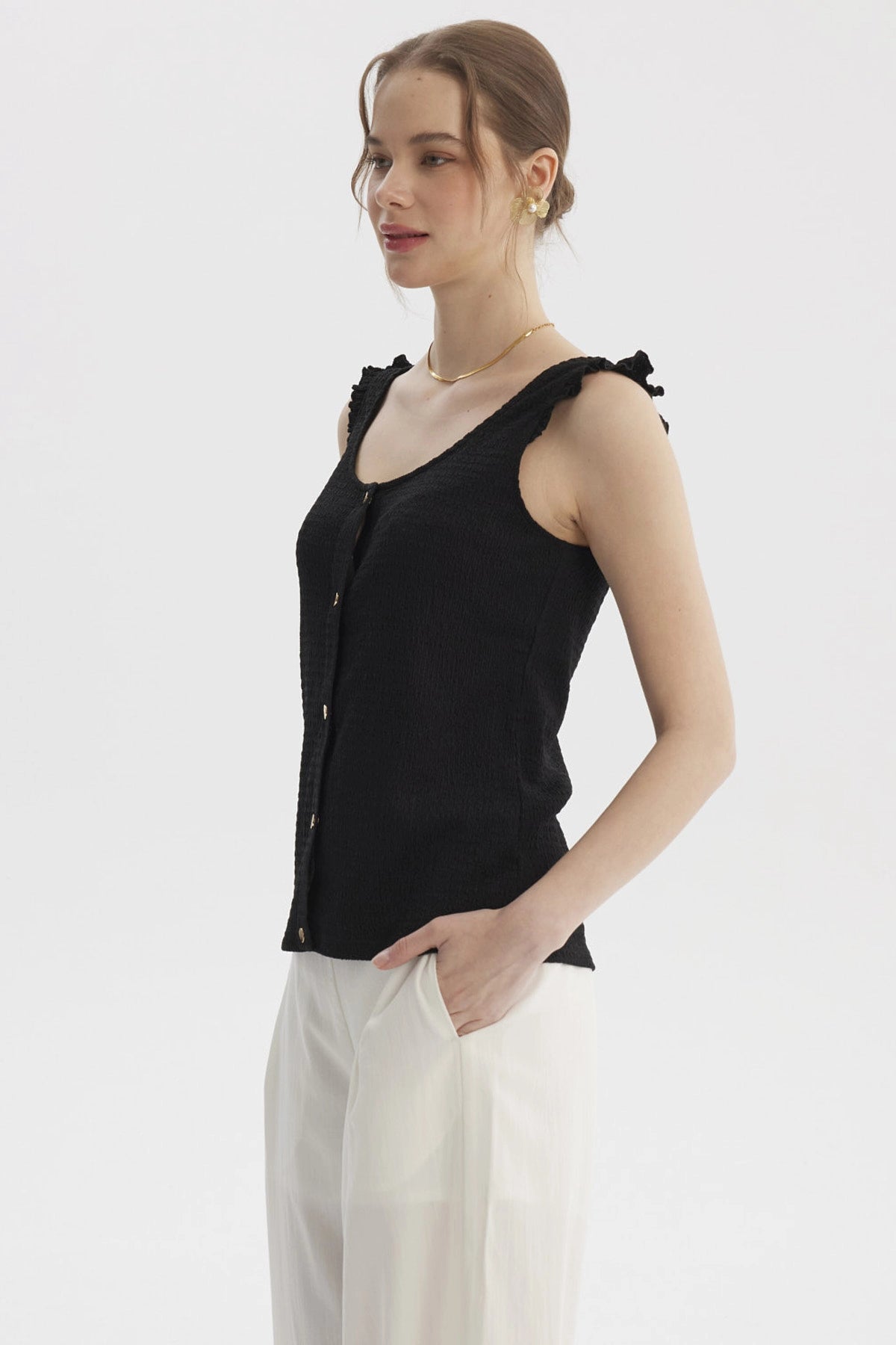 Polera negra sin mangas con vuelo y botones dorados lisa y elegante ideal para un look casual y fresco