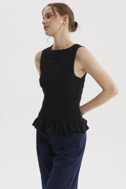 Blusa negra sin mangas con textura panal y vuelo en el bajo prenda lisa elegante para combinar con todo