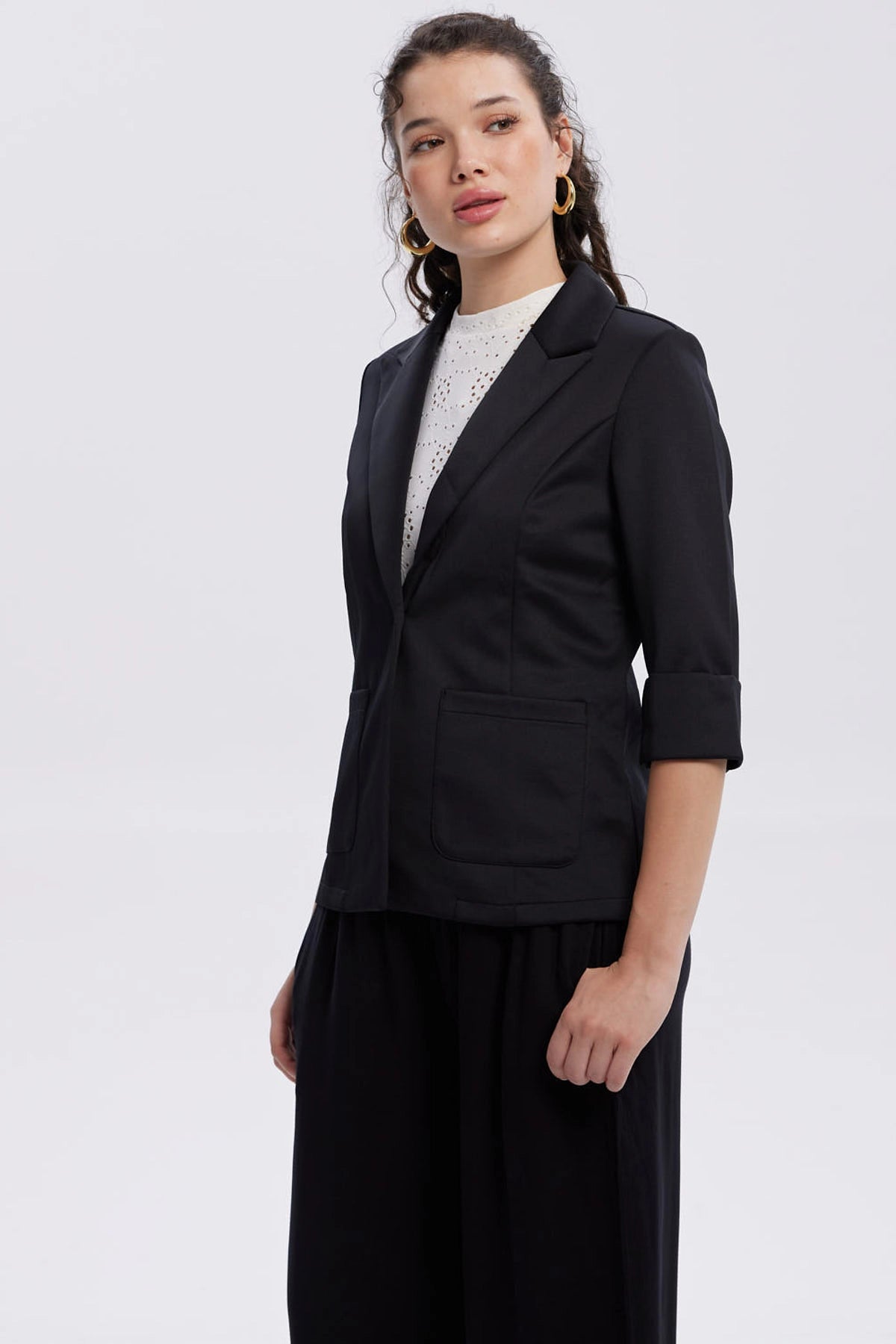 Blazer negro para mujer con mangas tres cuartos y botón frontal
