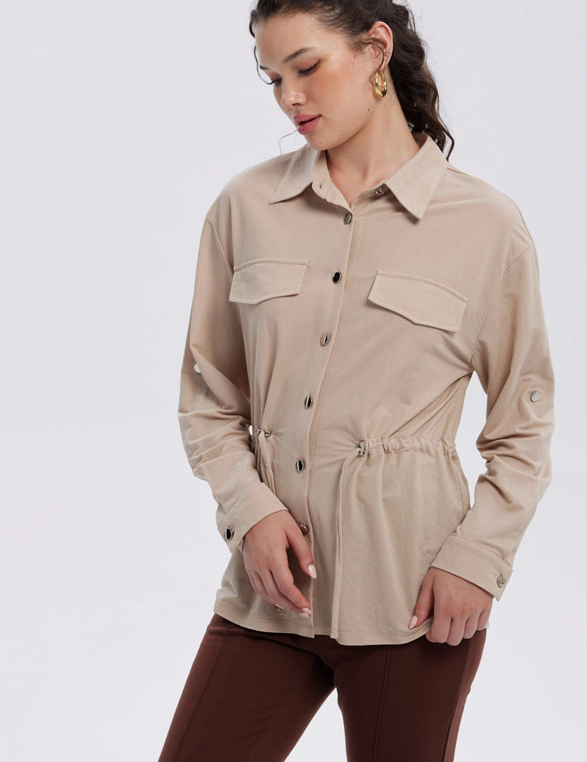 Chaqueta beige de mujer con bolsillos frontales y botones visibles