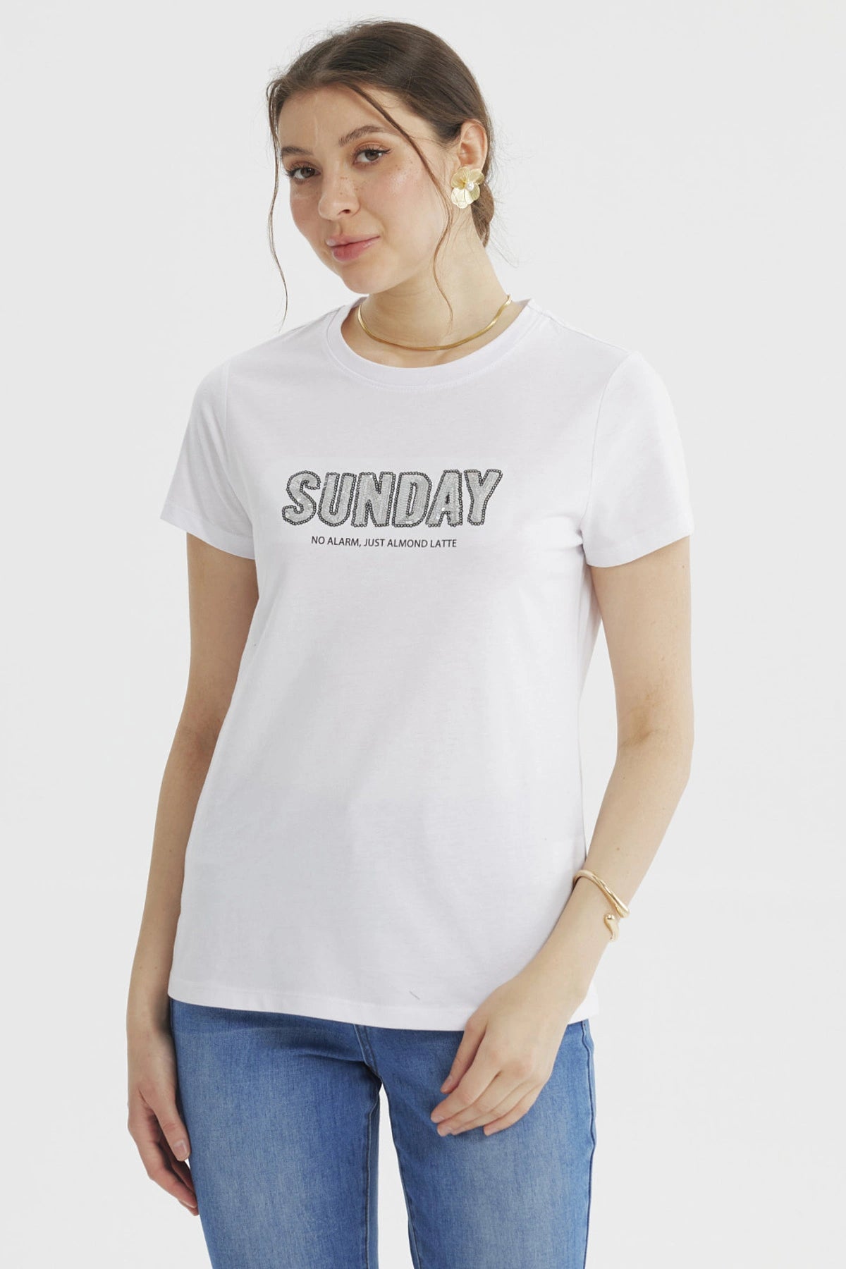 Polera blanca de mujer con texto 'SUNDAY' grande y 'NO ALARM JUST ALMOND LATTE' debajo en el pecho estilo casual