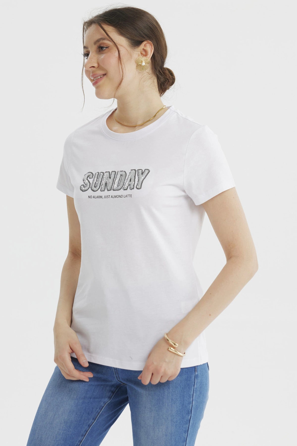 Polera blanca de mujer con texto 'SUNDAY' grande y 'NO ALARM JUST ALMOND LATTE' debajo en el pecho estilo casual